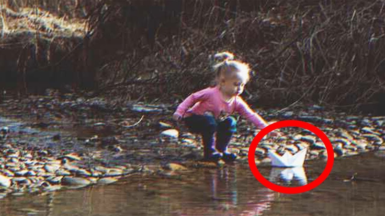 Fetița găsește o barcă de hârtie care navighează pe râu pe care este scris „Ajută-ne”.